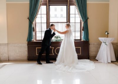 bride groom inside a room and infront of a window with a white marble tile floor